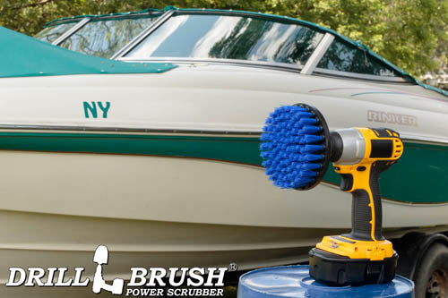 Drillbrush 5 inch Medium Blue Marine & Pool Brush in a cordless drill on a bucket  in front of a boat on a trailer in a backyard.