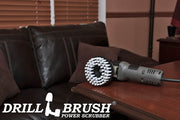 Drillbrush 5 inch Threaded Soft White Home & Auto Brush in a variable speed polisher on a wooden desk in front of a leather sofa.
