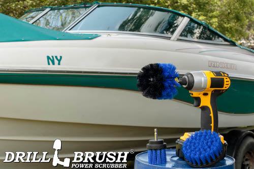 The Drillbrush 4OS-2L Medium Blue Marine & Pool Brush Kit in a cordless drill sitting on a bucket in front of a boat on a trailer in a backyard.