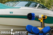 The Drillbrush 5542O Medium Blue Marine & Pool Brush Kit in a cordless drill sitting on a bucket in front of a boat on a trailer.