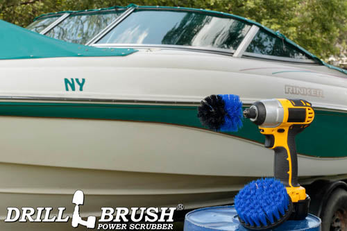 The Drillbrush 4M Medium Blue Marine & Pool Brush Kit in a cordless drill sitting on a bucket in front of a boat on a trailer.