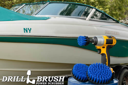 The Drillbrush 542 Medium Blue Marine & Pool Brush Kit in a cordless drill sitting on a bucket in front of a boat on a trailer.