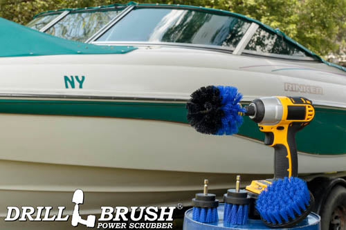 The Drillbrush 42OS-2L Medium Blue Marine & Pool Brush Kit in a cordless drill sitting on a bucket in front of a boat on a trailer.