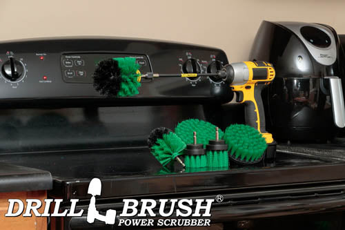 The Drillbrush 542OMS-2L Medium Green Kitchen Brush Kit in a cordless drill sitting on a stovetop in front of a coffeemaker.