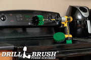 The Drillbrush 42O-5X Medium Green Kitchen Brush Kit in a cordless drill sitting on a stovetop in front of a coffee maker.