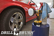 The Drillbrush 42 Soft White Home & Auto Brush Kit in a cordless drill sitting on a bucket next to a spray bottle and a rag in front of a red sports car.