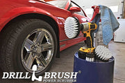 The Drillbrush 542 Soft White Home & Auto Brush Kit in a cordless drill sitting on a bucket next to a spray bottle and a rag in front of a red sports car.
