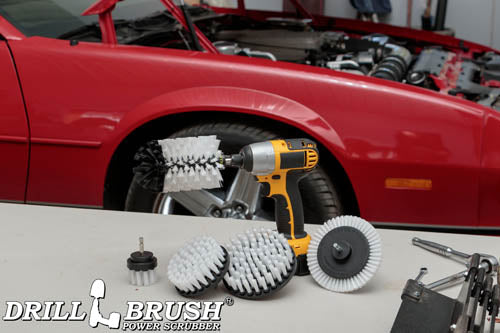 The Drillbrush E542J Soft White Home & Auto Brush Kit in a cordless drill sitting on a table in front of a red sports car.