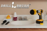 The Drillbrush 2O Medium Yellow Bathroom Brush Kit in a cordless drill sitting on a bathroom counter next to a sink and toiletries.