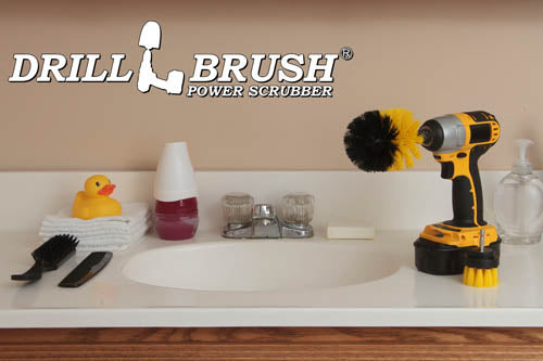 The Drillbrush 2O Medium Yellow Bathroom Brush Kit in a cordless drill sitting on a bathroom counter next to a sink and toiletries.