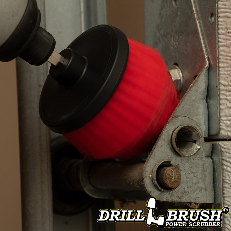 A Drillbrush Stiff Red Cone-shaped Corner brush cleaning in a garage.