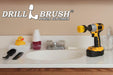 Drillbrush 2 inch Long Medium Yellow Bathroom Brush in a cordless drill on a bathroom counter in front of a sink and some toiletries.
