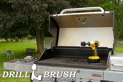 Drillbrush 2 inch Short Ultra Stiff Black Grill & Industrial Brush in a cordless drill on an open grill in front of a backyard.