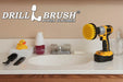 Drillbrush 4 inch Medium Yellow Bathroom Brush in a cordless drill on a bathroom counter in front of a sink and some toiletries.