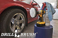 Drillbrush 5 inch Soft White Home & Auto Brush in a cordless drill on a bucket next to a spray bottle and shop rag in front of the rims of a red sports car.