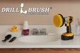 Drillbrush 5 inch Medium Yellow Bathroom Brush in a cordless drill on a bathroom counter in front of a sink and some toiletries.