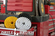 Drillbrush Soft White, Medium Yellow, and Ultra Stiff Black 3-piece Variety 7 inch Brush Kit in an open shelf of a tool box in front of other tool boxes with tools and equipment surrounding them.