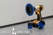 The Drillbrush EMS-2L Medium Blue Marine & Pool Brush Kit in a cordless drill sitting on a diamond plate floor in a garage.