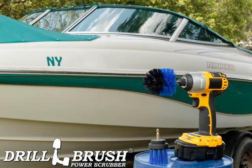 The Drillbrush MS-2L Medium Blue Marine & Pool Brush Kit in a cordless drill sitting on a bucket in front of a boat on a trailer in a backyard.