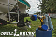 The Drillbrush 4O Medium Blue Marine & Pool Brush Kit in a cordless drill sitting on a bucket next to a spray bottle and rag in front of a boat on a trailer.