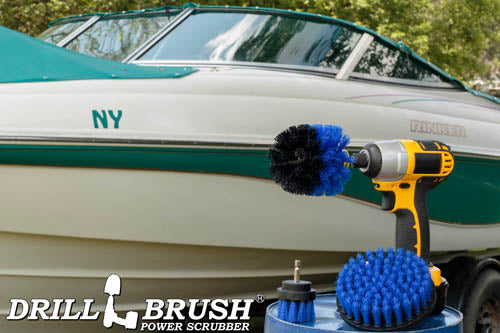 The Drillbrush 52O Medium Blue Marine & Pool Brush Kit in a cordless drill sitting on a bucket in front of a boat on a trailer.