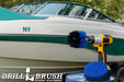 The Drillbrush 5O Medium Blue Marine & Pool Brush Kit in a cordless drill sitting on a bucket in front of a boat on a trailer.
