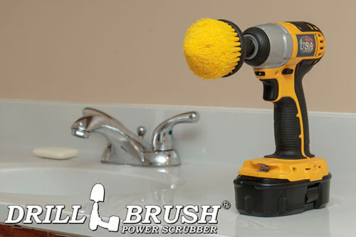 Drillbrush Medium Yellow Corner Brush in a cordless drill on a bathroom countertop.