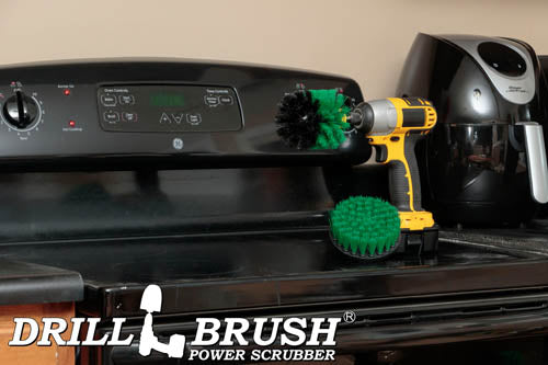 The Drillbrush 4O Medium Green Kitchen Brush Kit in a cordless drill sitting on a stovetop in front of a coffeemaker.