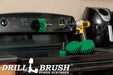 The Drillbrush 542O-7X Medium Green Kitchen Brush Kit in a cordless drill sitting on a stove top in front of a coffee maker.