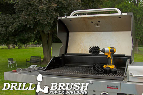 The Drillbrush 42OS-2L Ultra Stiff Black Grill & Industrial Brush Kit in a cordless drill sitting on an open grill in front of a grassy backyard.