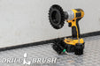 The Drillbrush EMS-2L Ultra Stiff Black Grill & Industrial Brush Kit in a cordless drill sitting on a diamond plate floor in a garage.