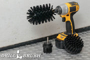 The Drillbrush 42J Ultra Stiff Black Grill & Industrial Brush Kit in a cordless drill sitting on a diamond plate floor in a garage.