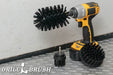 The Drillbrush 42J Ultra Stiff Black Grill & Industrial Brush Kit in a cordless drill sitting on a diamond plate floor in a garage.