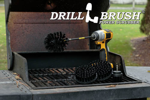 The Drillbrush 542O-7X Ultra Stiff Black Grill & Industrial Brush Kit in a cordless drill sitting on an open grill in front of a grassy backyard.