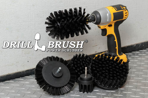 The Drillbrush E542J Ultra Stiff Black Grill & Industrial Brush Kit in a cordless drill sitting on a diamond plate floor in a garage.