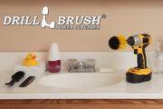 Drillbrush Mini Medium Yellow Bathroom Brush in a cordless drill on a bathroom counter in front of a sink and some toiletries.