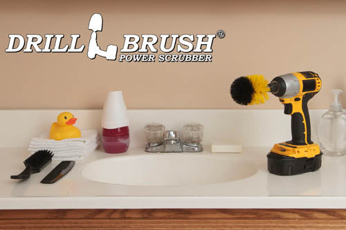 Drillbrush Mini Medium Yellow Bathroom Brush in a cordless drill on a bathroom counter in front of a sink and some toiletries.