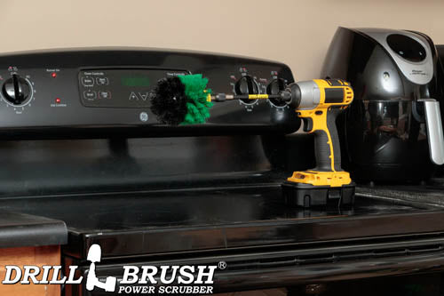 Drillbrush Original Medium Green Kitchen Brush in a 5 inch extension on a stovetop in front of an air fryer.
