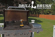 Drillbrush Original Ultra Stiff Black Grill & Industrial Brush in a 7 inch extension on an opened grill in front of a backyard.