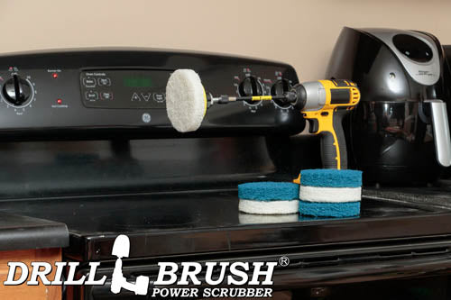 The Drillbrush 3 Soft White & 3 Stiff Blue 4 inch Scrubbing Pads and 5 inch extension Kit,  with one pad on a 3 inch backer attached to an extension in a cordless drill on a kitchen stovetop in front of a coffeemaker.
