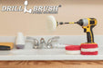 The Drillbrush 3 Soft White & 3 Moderate Red 4 inch Scrubbing Pads and 5 inch extension Kit, with one pad on a 3 inch backer attached to an extension in a cordless drill on a bathroom counter in front of a sink.