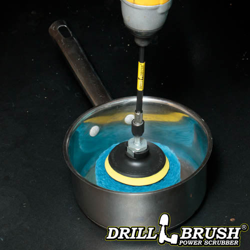 The Drillbrush Stiff Blue 4 inch Scrubbing Pads on a 3 inch backer attached to an extension in a cordless drill cleaning a sauce pan.