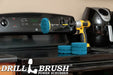 The Drillbrush 6 Stiff Blue 4 inch Scrubbing Pads and 5 inch extension Kit, with one pad on a 3 inch backer attached to an extension in a cordless drill on a kitchen stovetop in front of a coffeemaker.