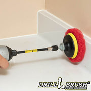 The Drillbrush Moderate Red 4 inch Scrubbing Pads on a 3 inch backer attached to an extension in a cordless drill cleaning the backsplash on a bathroom counter.