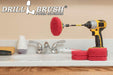 The Drillbrush 6 Moderate Red 4 inch Scrubbing Pads and 5 inch extension Kit, with one pad on a 3 inch backer attached to an extension in a cordless drill on a bathroom counter in front of a sink.