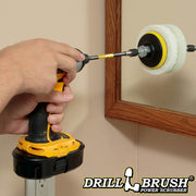 The Drillbrush White 4 inch Scrubbing Pads on a 3 inch backer attached to an extension in a cordless drill cleaning a bathroom cabinet mirror.