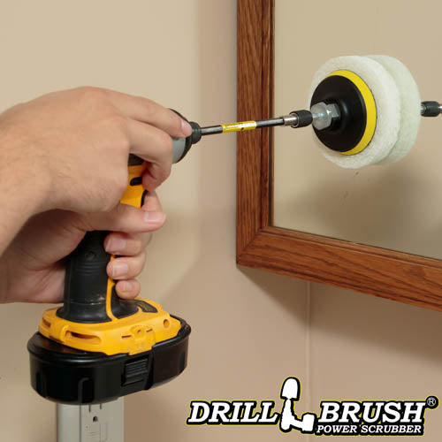 The Drillbrush White 4 inch Scrubbing Pads on a 3 inch backer attached to an extension in a cordless drill cleaning a bathroom cabinet mirror.