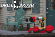 The Drillbrush 542OMS-2L Red Stiff Outdoor & Patio Brush Kit in a cordless drill sitting on a deck railing in front of vinyl furniture.