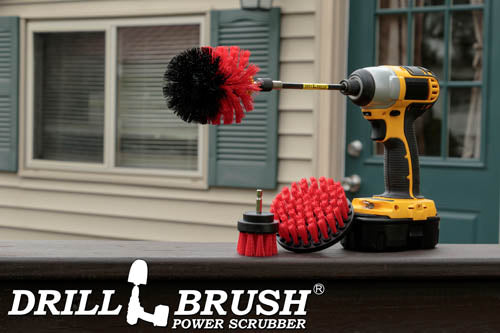 The Drillbrush 42O-5X Red Stiff Outdoor & Patio Brush Kit in a cordless drill sitting on a deck railing in front of a back door and window.