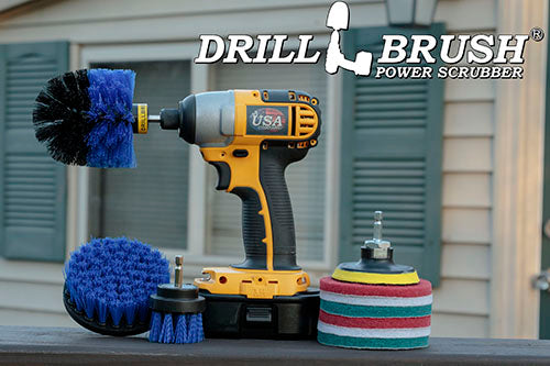 The Medium Blue Drillbrush 42O Marine & Pool Kit with three 4 inch Variety Pads with an Original in a cordless drill on a wooden railing on a deck in front of window.